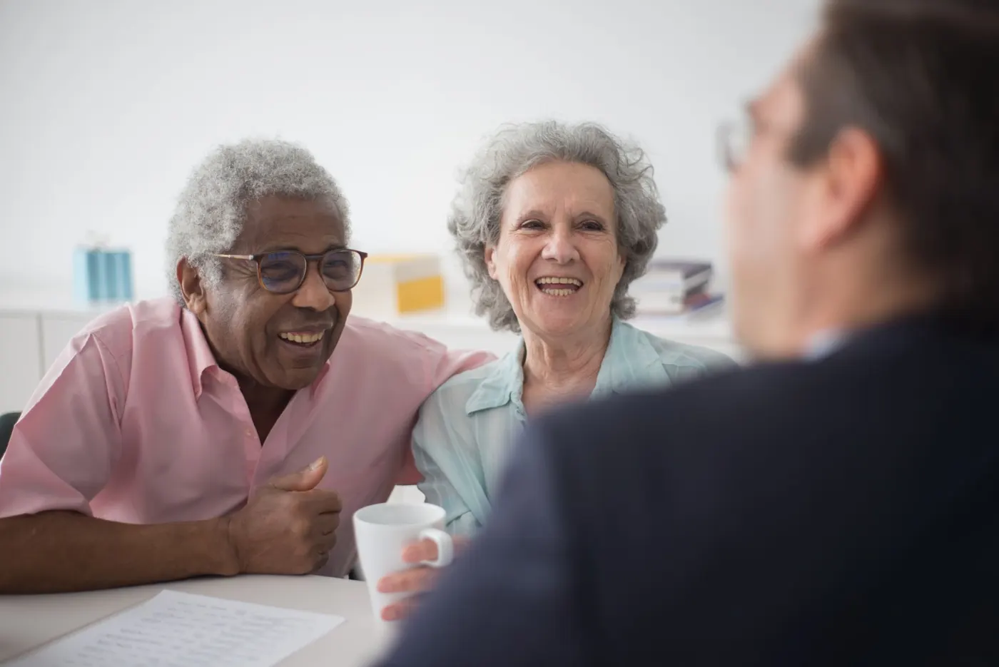 An older couple laughing while talking with an advisor