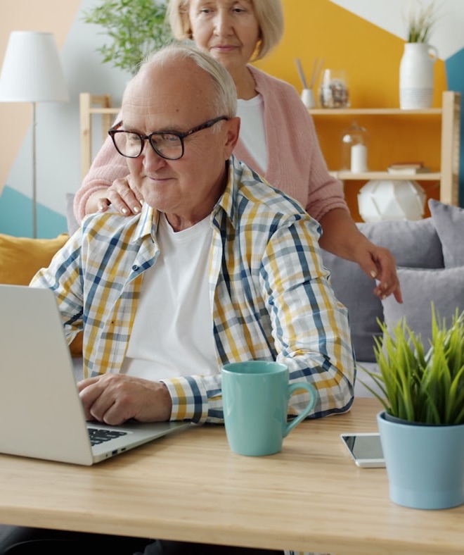 A senior couple looking at a laptop together at home